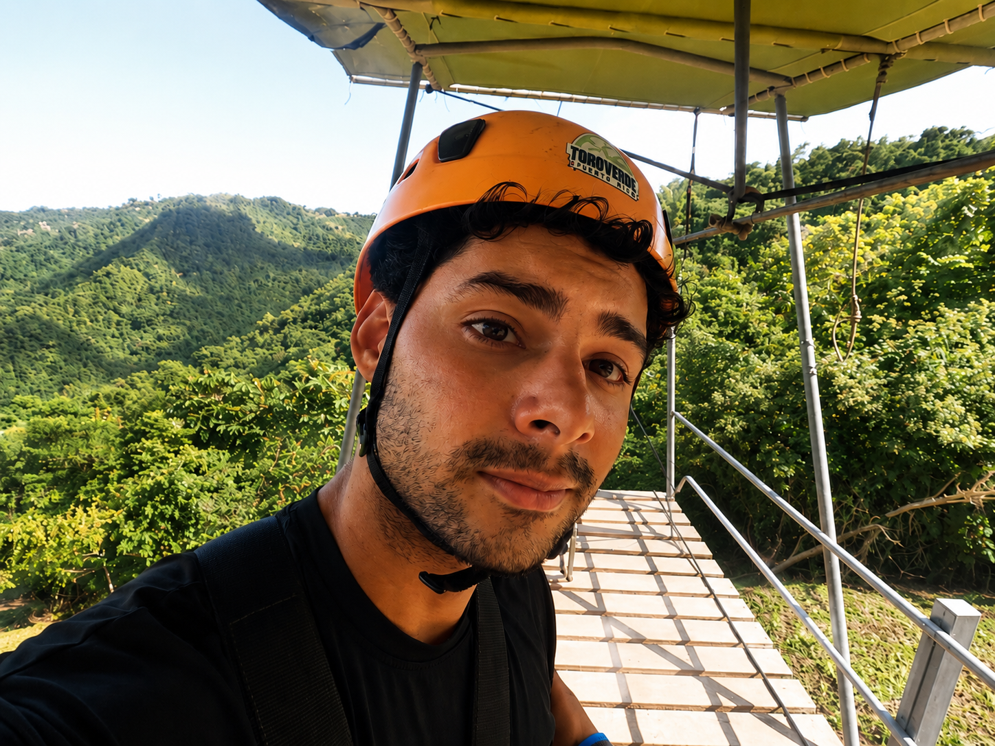 Jean Batista wearing an orange helmet in the mountains.